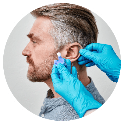 Audiologist examing a mans ear to make a pair of custom earmolds
